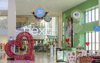 A photograph of St. Marks shopping centre with Fizzco's Giant Red Heart Seat and Hanging decorations to celebrate Valentine's day, St.Mark's 30th Birthday and St.Barnabas' Hospice 40th Anniversary.