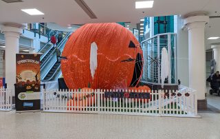 A photograph of Alhambra shopping centre with a giant Halloween pumpkin displayed in the centre.